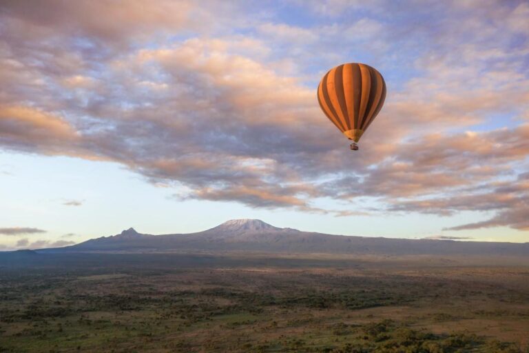 En luftballong over sletta, med Kilimanjaro i horisonten under en rosa himmel