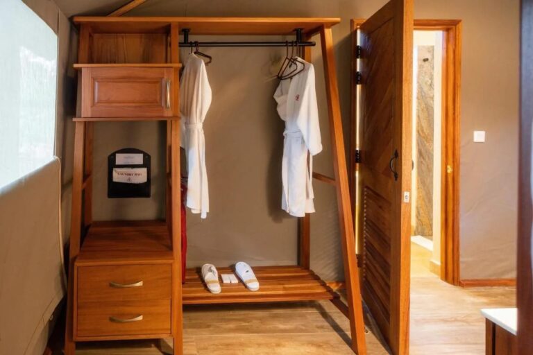 En åpen garderobe med to badekåper og tøfler, ved døra til badet