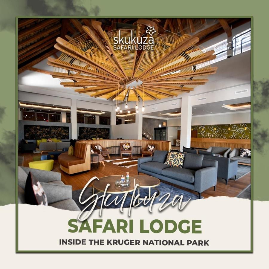 Salongen i lobbyen på Skukuza Safari Lodge under et stjerneformet tak av treribber, med navnet på lodgen skrevet over
